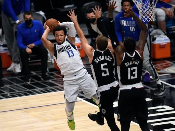 Jalen Brunson of the Dallas Mavericks passes the ball against Luke Kennard and Paul George of the Los Angeles Clippers during the first half of Game...
