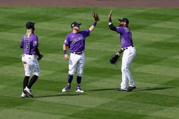 Raimel Tapia, Garrett Hampson and Charlie Blackmon of the Colorado Rockies celebrate a 3-1 win against the Oakland Athletics at Coors Field on June...