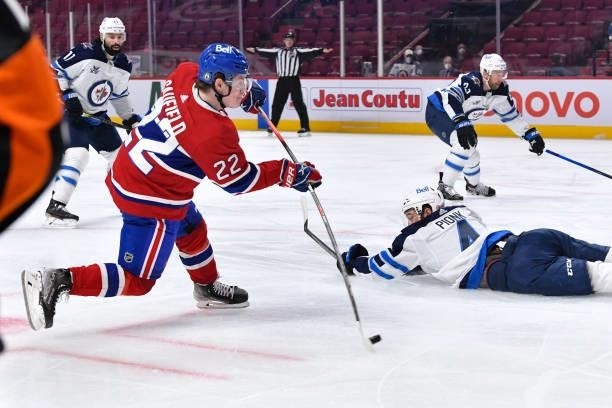 June 6: Cole Caufield of the Montreal Canadiens fires a shot while Neal Pionk of the Winnipeg Jets slides trying to block the shot in Game Three of...