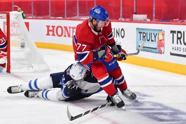 Mason Appleton of the Winnipeg Jets falls as he skates against Brett Kulak of the Montreal Canadiens during the first period in Game Three of the...