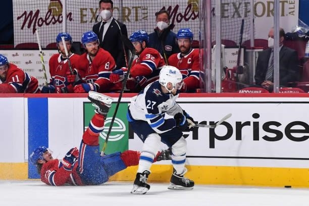 Tyler Toffoli of the Montreal Canadiens falls to the ice after losing a puck battle against Nikolaj Ehlers of the Winnipeg Jets during the first...