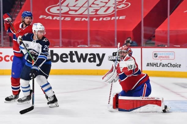 Goaltender Carey Price of the Montreal Canadiens gloves the puck while teammate Eric Staal battles for position with Paul Stastny of the Winnipeg...