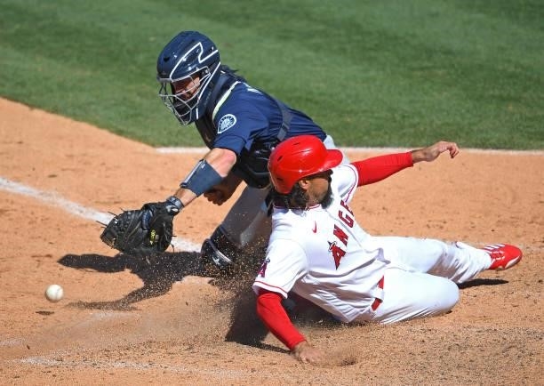 Anthony Rendon of the Los Angeles Angels beats the throw to Tom Murphy of the Seattle Mariners as he scores on a double by Jose Iglesias of the Los...