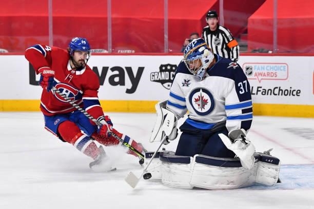 Goaltender Connor Hellebuyck of the Winnipeg Jets makes a pad save near Phillip Danault of the Montreal Canadiens during the second period in Game...