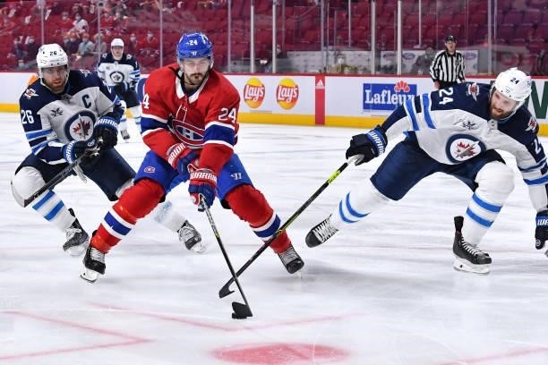 June 6: Phillip Danault of the Montreal Canadiens controls the puck while being challenged by Derek Forbort of the Winnipeg Jets in Game Three of the...