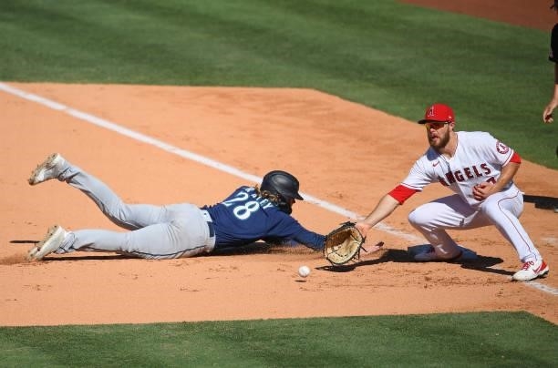 Jake Fraley of the Seattle Mariners beat the throw to Jared Walsh of the Los Angeles Angels back to first base in the ninth inning at Angel Stadium...