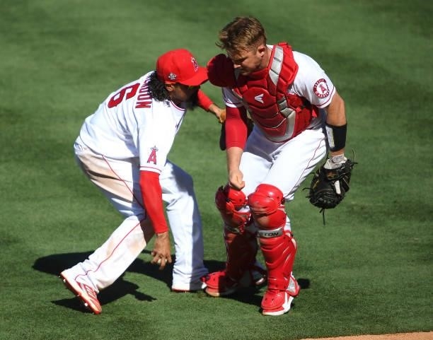 Anthony Rendon and Max Stassi of the Los Angeles Angels get crossed up as they field a bunt by Jack Mayfield of the Seattle Mariners in the ninth...