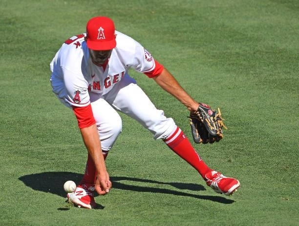 Steve Cishek of the Los Angeles Angels has trouble fielding and infield hit by Ty France of the Seattle Mariners in the ninth inning at Angel Stadium...