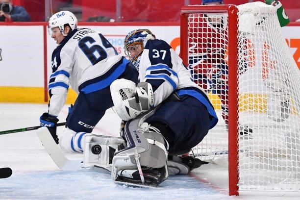 Goaltender Connor Hellebuyck of the Winnipeg Jets makes a save against the Montreal Canadiens during the second period in Game Three of the Second...