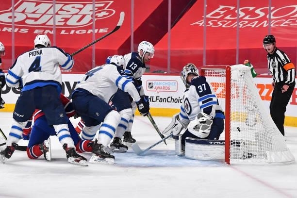 Goaltender Connor Hellebuyck of the Winnipeg Jets allows a goal against the Montreal Canadiens during the second period in Game Three of the Second...