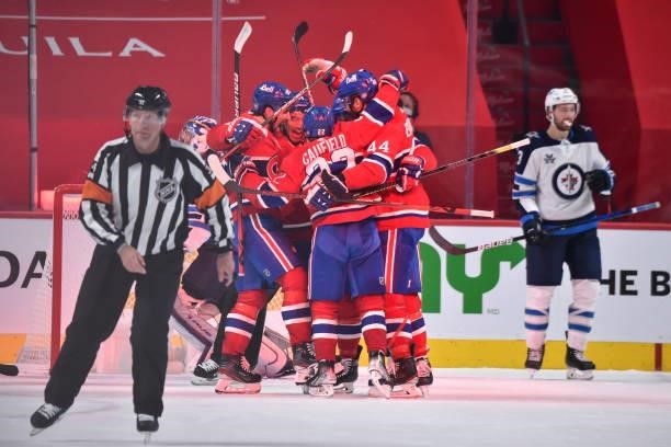 Nick Suzuki of the Montreal Canadiens celebrates his goal with teammates against the Winnipeg Jets during the third period in Game Three of the...