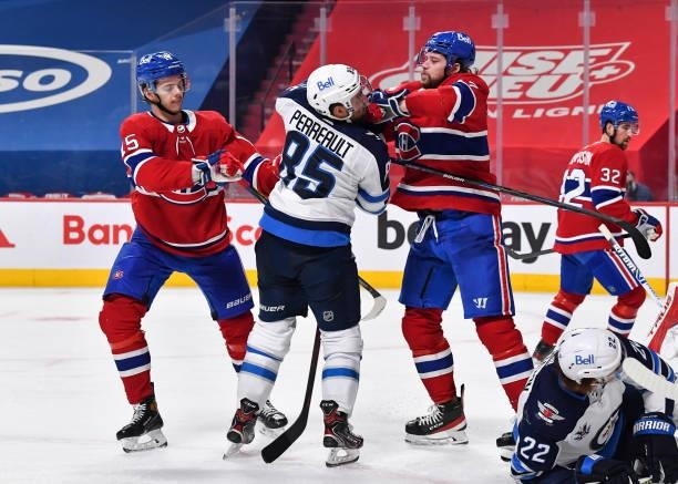 Jesperi Kotkaniemi and Josh Anderson of the Montreal Canadiens defend against Mathieu Perreault of the Winnipeg Jets during the third period in Game...