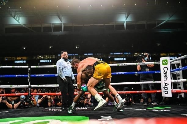 Former world welterweight king Floyd Mayweather dives under YouTube personality Logan Paul as they fight in an eight-round exhibition bout at Hard...