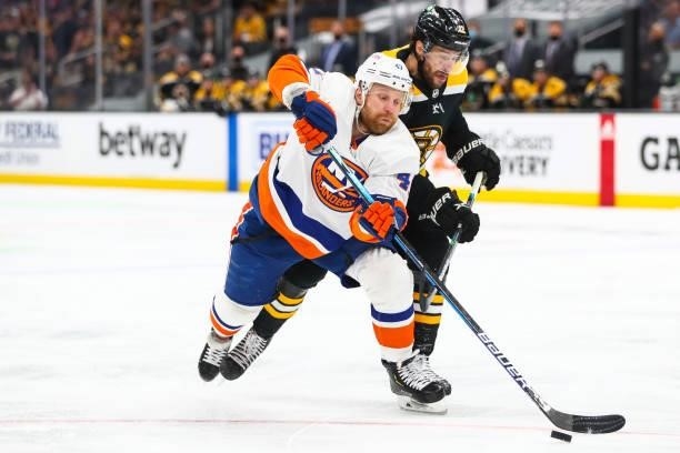 Leo Komarov of the New York Islanders and Craig Smith of the Boston Bruins fight for the puck in the first period in Game Five of the Second Round of...