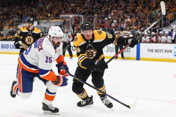 Cal Clutterbuck of the New York Islanders and Jeremy Lauzon of the Boston Bruins skate towards the puck in the second period in Game Five of the...