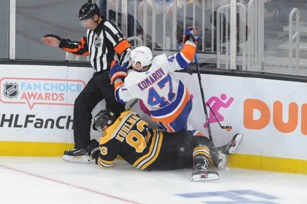 Leo Komarov of the New York Islanders falls over Karson Kuhlman of the Boston Bruins in Game Five of the Second Round of the 2021 Stanley Cup...