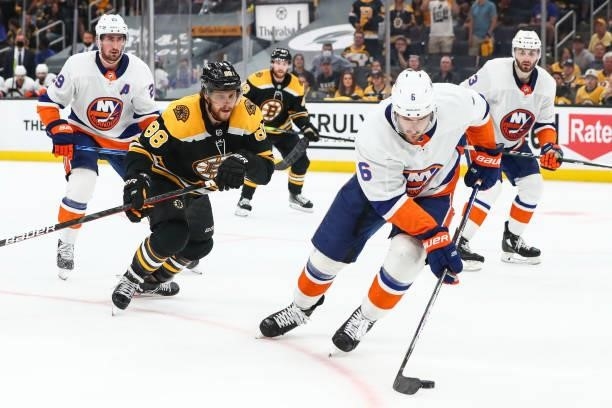 David Pastrnak of the Boston Bruins challenges Ryan Pulock of the New York Islanders for the puck in the third period in Game Five of the Second...