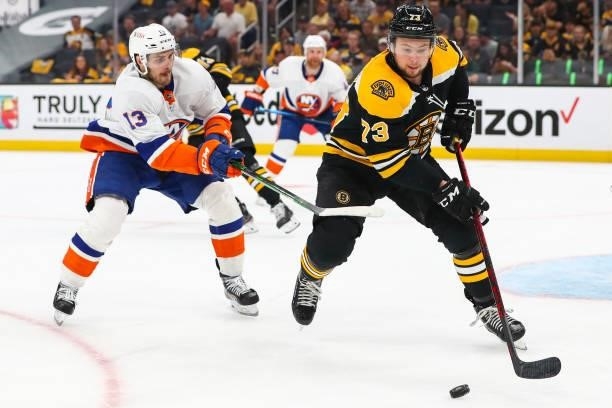Charlie McAvoy of the Boston Bruins and Mathew Barzal of the New York Islanders fight for the puck in the second period in Game Five of the Second...