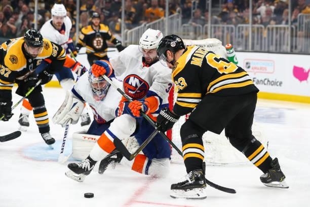 Adam Pelech of the New York Islanders and Brad Marchand of the Boston Bruins fight for the puck in the third period in Game Five of the Second Round...