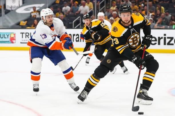 Charlie McAvoy of the Boston Bruins controls the puck alongside Mathew Barzal of the New York Islanders in the second period in Game Five of the...