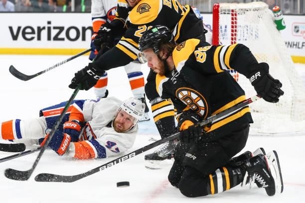 Leo Komarov of the New York Islanders and David Pastrnak of the Boston Bruins fight for the puck in front of the net in the third period in Game Five...