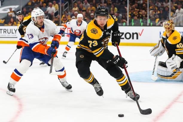 Charlie McAvoy of the Boston Bruins and Mathew Barzal of the New York Islanders fight for the puck in the second period in Game Five of the Second...
