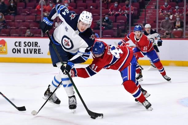 June 7: Logan Stanley of the Winnipeg Jets skates with the puck under pressure from Paul Byron of the Montreal Canadiens in Game Four of the Second...