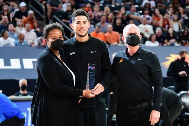 Devin Booker of the Phoenix Suns receives the NBA Cares Community Assist Award before the game against the Denver Nuggets during Round 2, Game 1 of...