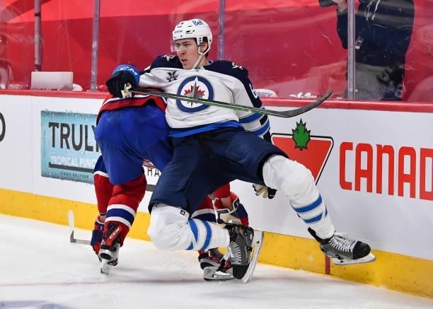 Logan Stanley of the Winnipeg Jets falls over Corey Perry of the Montreal Canadiens during the second period in Game Four of the Second Round of the...
