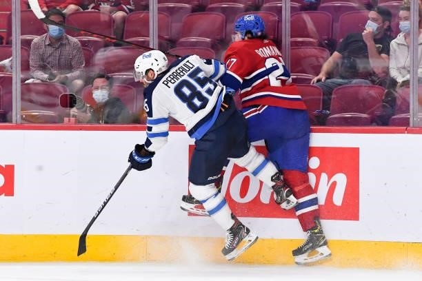June 7: Mathieu Perreault of the Winnipeg Jets checks Alexander Romanov of the Montreal Canadiens in Game Four of the Second Round of the 2021...