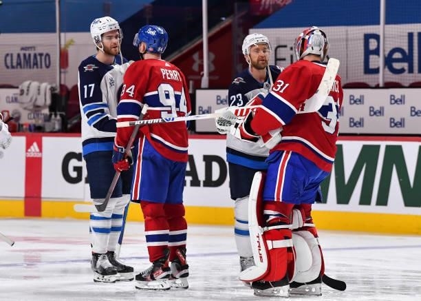 Adam Lowry and Trevor Lewis of the Winnipeg Jets shake hands with Corey Perry and Carey Price of the Montreal Canadiens following the Canadiens 3-2...
