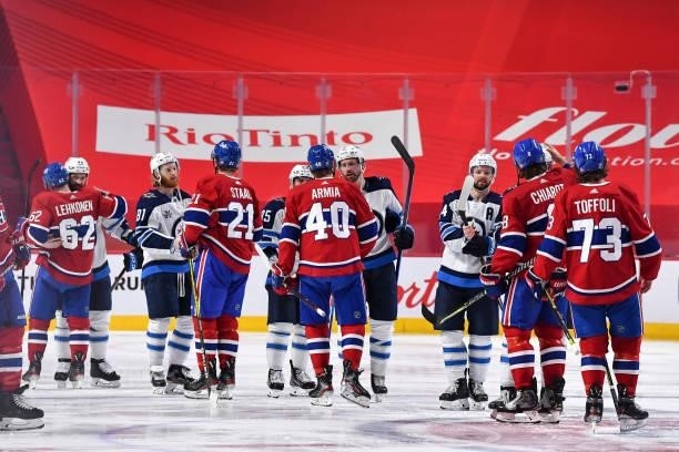 The Winnipeg Jets and the Montreal Canadiens shake hands following the Canadiens 3-2 overtime victory to close out the series in Game Four of the...