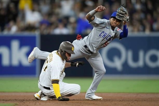 Victor Caratini of the San Diego Padres slides into second base ahead of the tag of Sergio Alcantara of the Chicago Cubs during the second inning of...