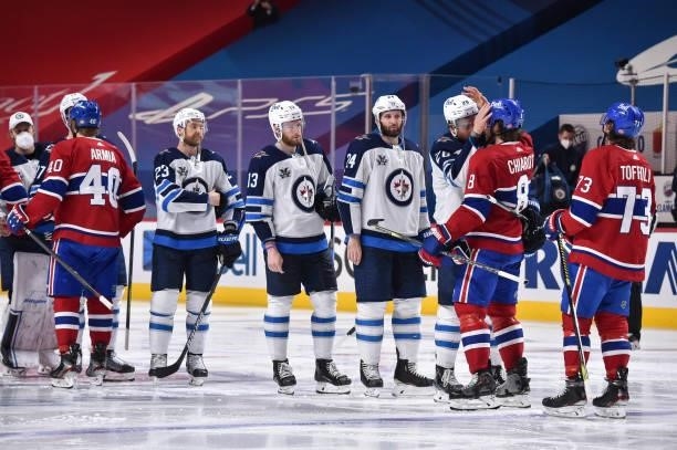 The Winnipeg Jets and the Montreal Canadiens shake hands following the Canadiens 3-2 overtime victory to close out the series in Game Four of the...