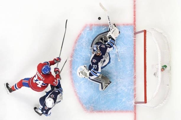June 7: Goaltender Connor Hellebuyck of the Winnipeg Jets makes a save off the shot by Phillip Danault of the Montreal Canadiens in Game Four of the...