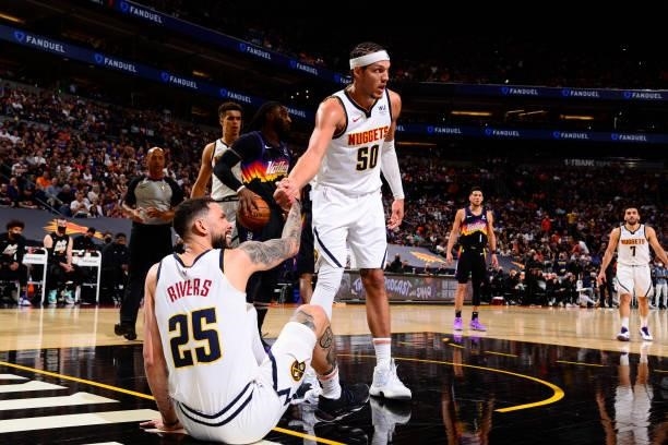 Aaron Gordon helps up Austin Rivers of the Denver Nuggets during Round 2, Game 1 of the 2021 NBA Playoffs on June 7, 2021 at Phoenix Suns Arena in...