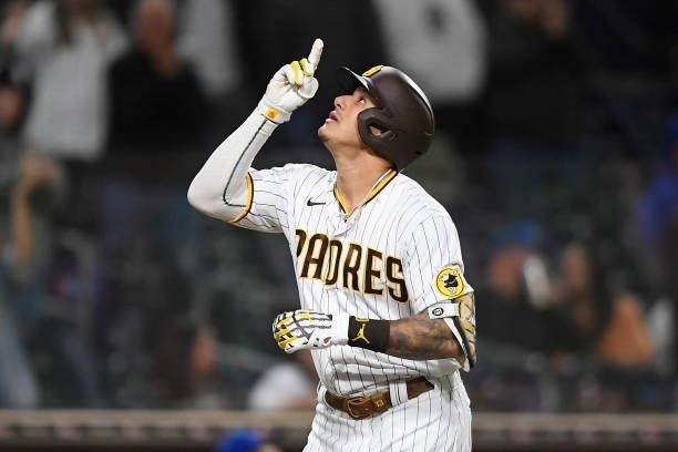 Manny Machado of the San Diego Padres points skyward after hitting a solo home run during the eighth inning of a baseball game against the Chicago...