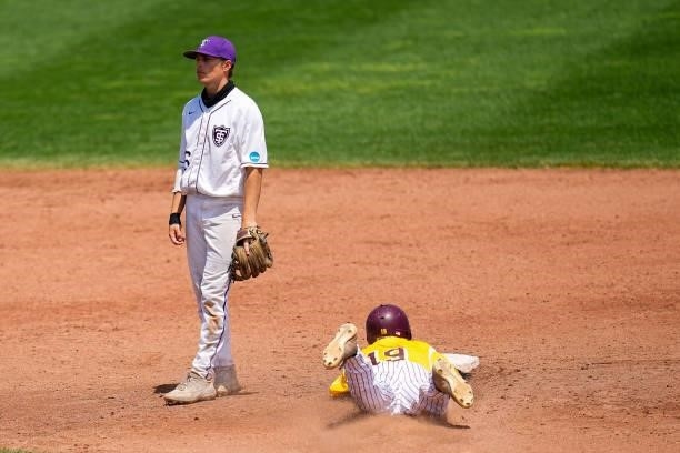 Ethan Sarosi slides safe into second on a steal as a dejected Sam Kulesa of St. Thomas looks on during the Division III Men's Baseball Championship...