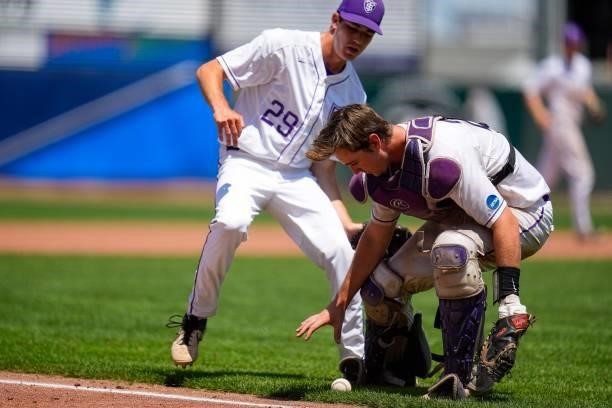 Charlie Bartholomew of St. Thomas reaches for a bunted ball as T.J. Constertina looks on during the Division III Men's Baseball Championship against...