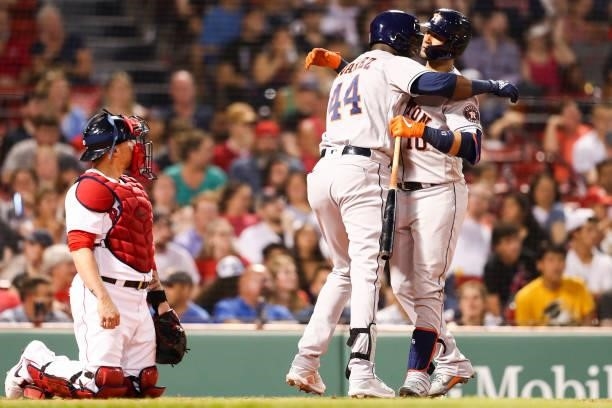 Kevin Plawecki of the Boston Red Sox looks on as Yordan Alvarez hugs Yuli Gurriel of the Houston Astros after hitting a solo home run in the fourth...