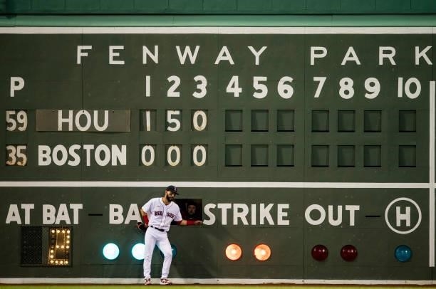 Marwin Gonzalez of the Boston Red Sox leans against the Green Monster Scoreboard during the fourth inning of a game against the Houston Astros on...