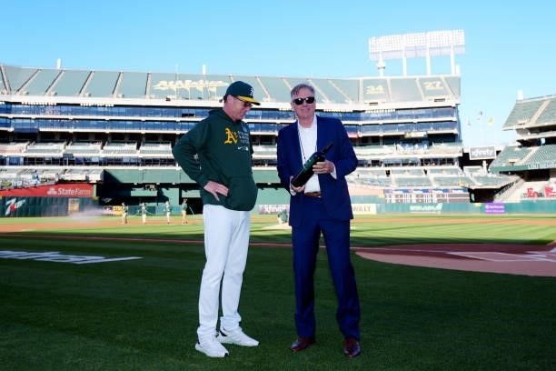 Executive Vice President of Baseball Operations of the Oakland Athletics Billy Bean presents Manager Bob Melvin a bottle of wine for his work with...