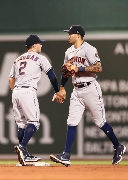 Alex Bregman high fives Carlos Correa of the Houston Astros after a win over the Boston Red Sox at Fenway Park on June 8, 2021 in Boston,...
