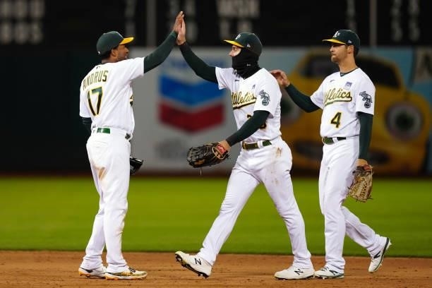 Elvis Andrus of the Oakland Athletics celebrates with Mark Canha and Chad Pinder after the game between the Arizona Diamondbacks and the Oakland...