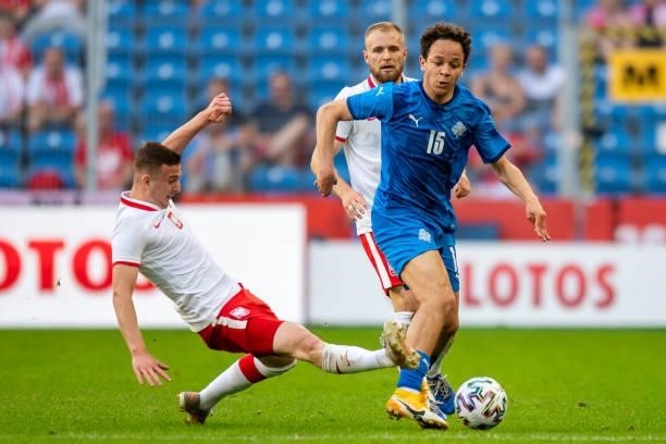 Kacper Kozlowski of Poland and Mikael Anderson of Iceland battle for the ball during the international friendly match between Poland and Iceland at...