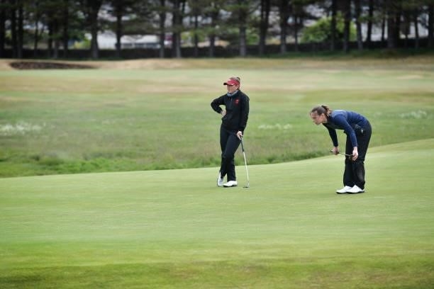 Ffion Tynan and Ashleigh Critchley line up their putts on the 14th green during Day Three of the R&A Womens Amateur Championship at Kilmarnock Golf...