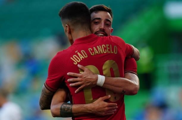 Bruno Fernandes of Portugal and Manchester United celebrates with teammate Joao Cancelo of Portugal and Manchester City after scoring a goal during...
