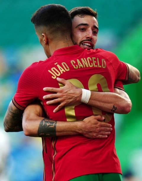 Bruno Fernandes of Portugal and Manchester United celebrates with teammate Joao Cancelo of Portugal and Manchester City after scoring a goal during...