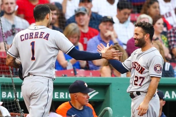 Carlos Correa reacts with Jose Altuve of the Houston Astros after scoring in the third inning of a game against the Boston Red Sox at Fenway Park on...