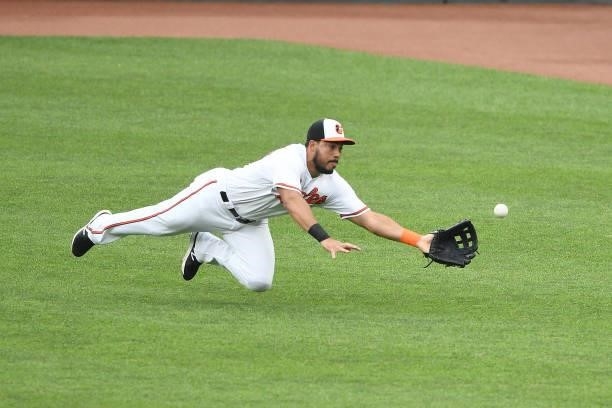 Anthony Santander of the Baltimore Orioles is unable to catch a ball hit by James McCann of the New York Mets during a game at Oriole Park at Camden...